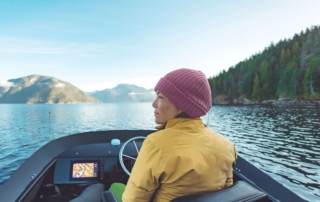 A woman looking at the shoreline and maybe Alaska Hunting.